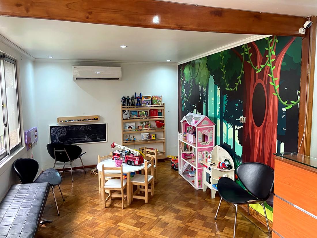 Sala de espera Lasan Kids con mural de árbol